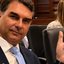 Flávio Bolsonaro em reunião nos EUA. Mão de Flávio Bolsonaro com escrita "PT Tax Party", que significa PT, partido das taxas