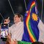 João Campos fala em microfone enquanto segura bandeira de Pernambuco