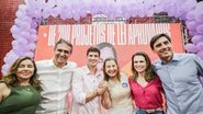 João Campos ao lado de Marília Arraes, Carlos Costa, uma mulher, Mário Ricardo e outra mulher. Ao fundo painel de bexigas lilás