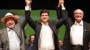 João Campos com as mãos unidas levantadas com Lula e Alckmin, todos sorriem