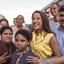Ao redor de crianças e outras pessoas Raquel Lyra e Eduardo da Fonte sorriem