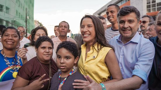 Ao redor de crianças e outras pessoas Raquel Lyra e Eduardo da Fonte sorriem