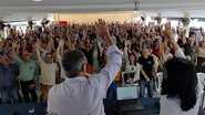 Diversas pessoas com as mãos levantadas