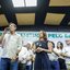 Raquel Lyra olha para Daniel Coelho enquanto ele fala em microfone, também observam mais ao fundo Miguel Coelho, Fernando Dueire, Priscila Krause, Mirella Almeida
