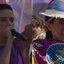 Raquel Lyra fala ao microfone, ao lado foto de Raquel Lyra com chapeu de couro com estampa de pernambuco e manto de maracatu