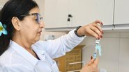 Enfermeira transferindo material de vacina para seringa