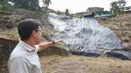 Victor Marques ao lado de encosta coberta por lona