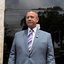 Luiz Rocha olha para frente de terno e olha em frente à sede da Polícia Federal