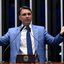 Flávio Bolsonaro com as mãos abertas e expressão de raiva ou tristeza