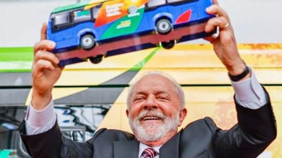 Presidente Lula segura miniatura de ônibus