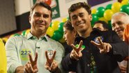 Flávio Bolsonaro e Nikolas Ferreira sorriem fazendo o símbolo de 2 e 2 com as mãos
