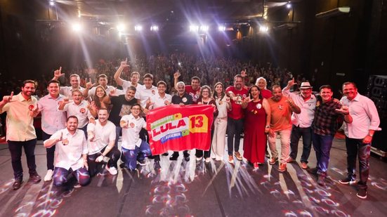 victor marques teresa leitão humberto costa joão campos silvio costa filho e outros sorriem em palco de teatro segurando bandeira escrito Lula 13
