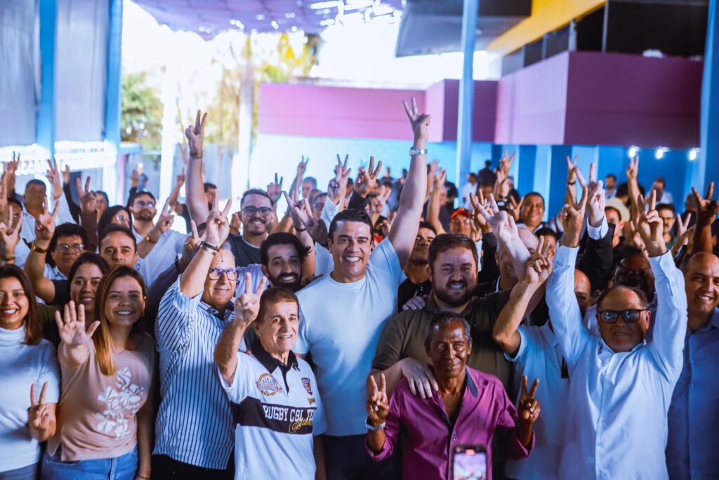 multidão sorrindo para câmera fazendo o número 2 em relação ao número 20 do partido podemos, o prefeito Rodrigo Pinheiro está no centro da imagem