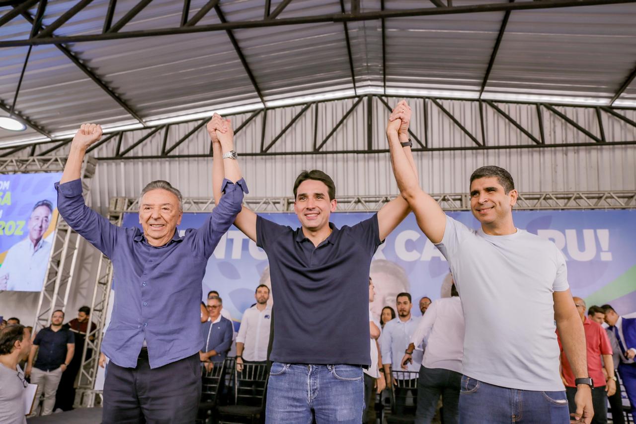 Políticos em palanque levantam as mãos unidas enquanto sorriem