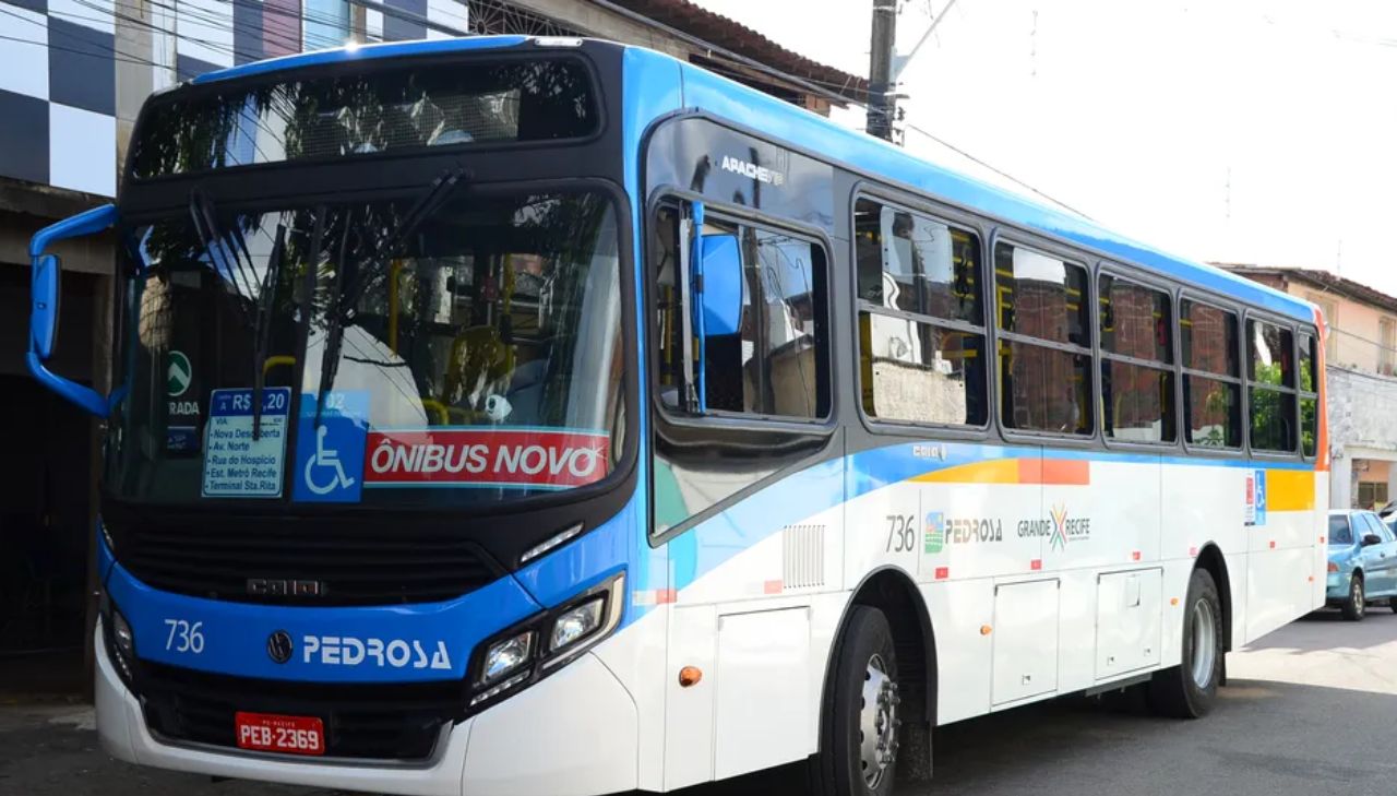 Imagem de um ônibus público azul enquanto circula nas ruas da cidade