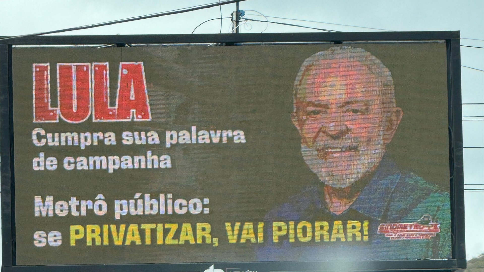 Painel de LED na rua com foto de Lula escrito "Lula cumpra sua palavra de campanha. Metrô Público: se privatizar, vai piorar!"