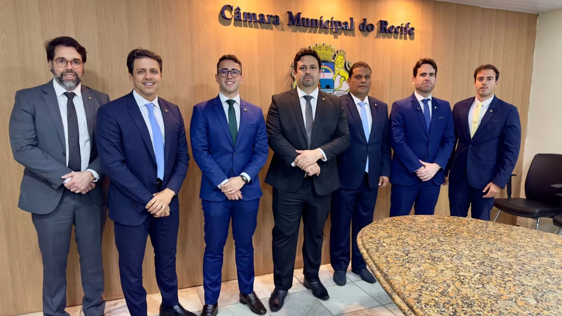 Paulo Muniz, Fred Ferreira, Thiago Medina, Felipe Alecrim, Davi Muniz, Eduardo Moura e Gilson Filho possam em frente ao escudo da Câmara Municipal do Recife