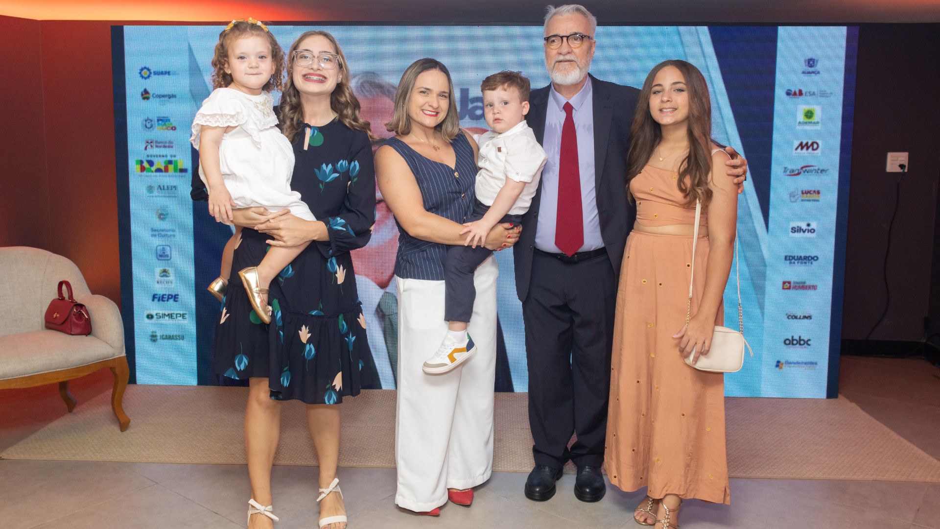 Jamildo, Ana Luiza Melo, uma jovem loira com uma menina pequena loira no braço. Ana Luiza tem um menino ruivo de 3 anos no braço. Ao lado de Jamildo está uma jovem loira de 12 anos