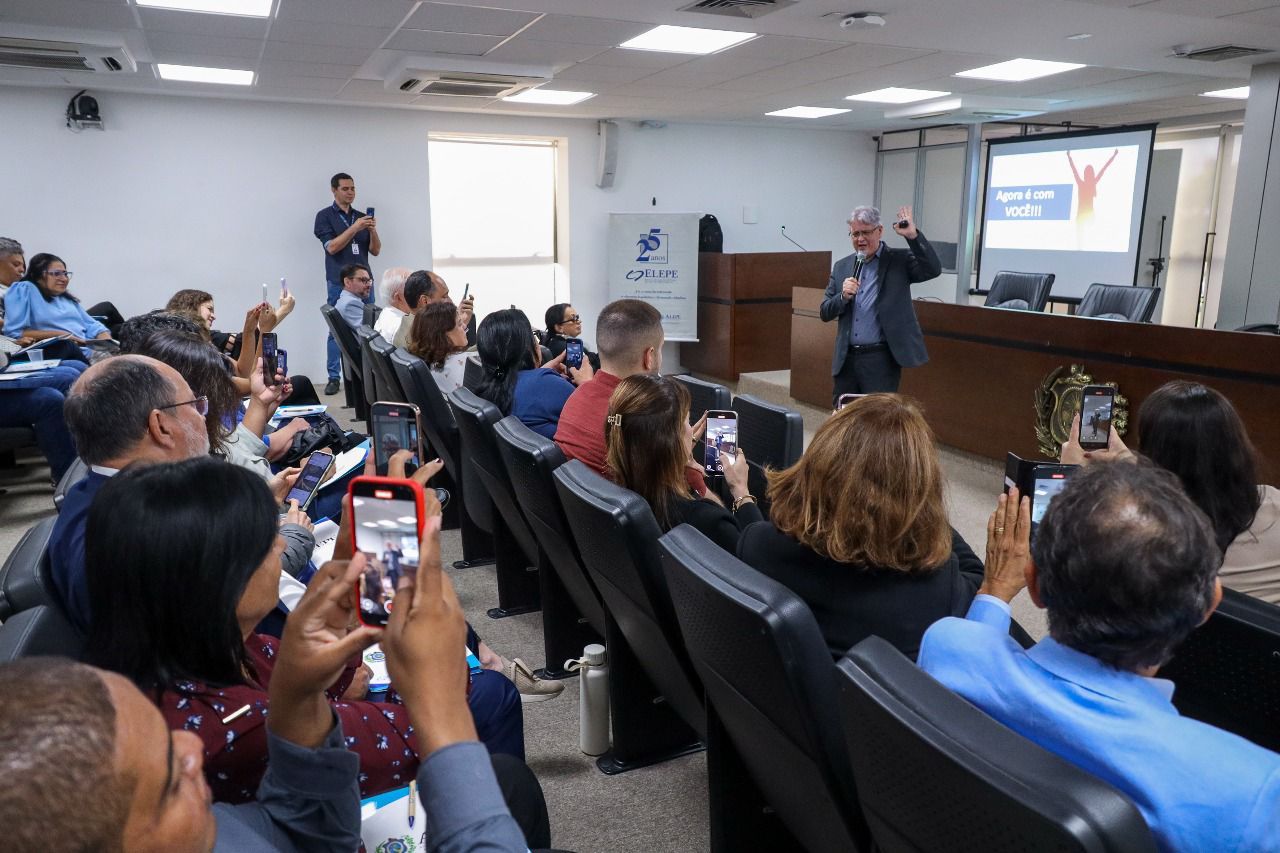 Pessoas sentadas nas cadeiras do auditório