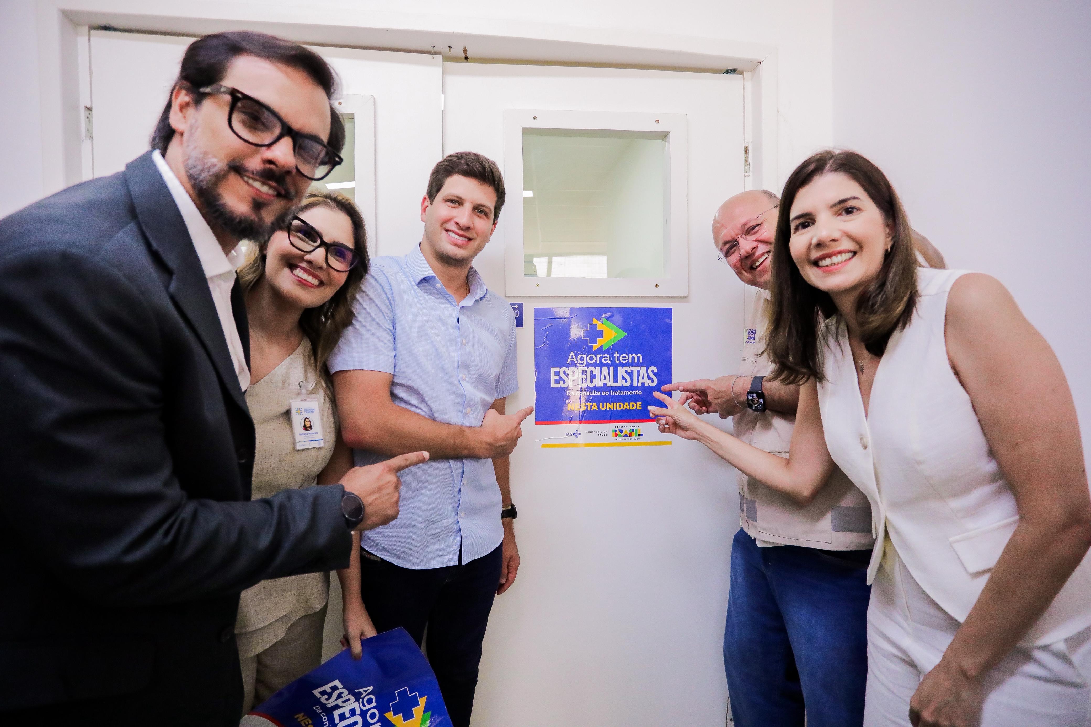 Prefeito e secretários apontado para adesivo do programa "Agora Tem Especialistas".