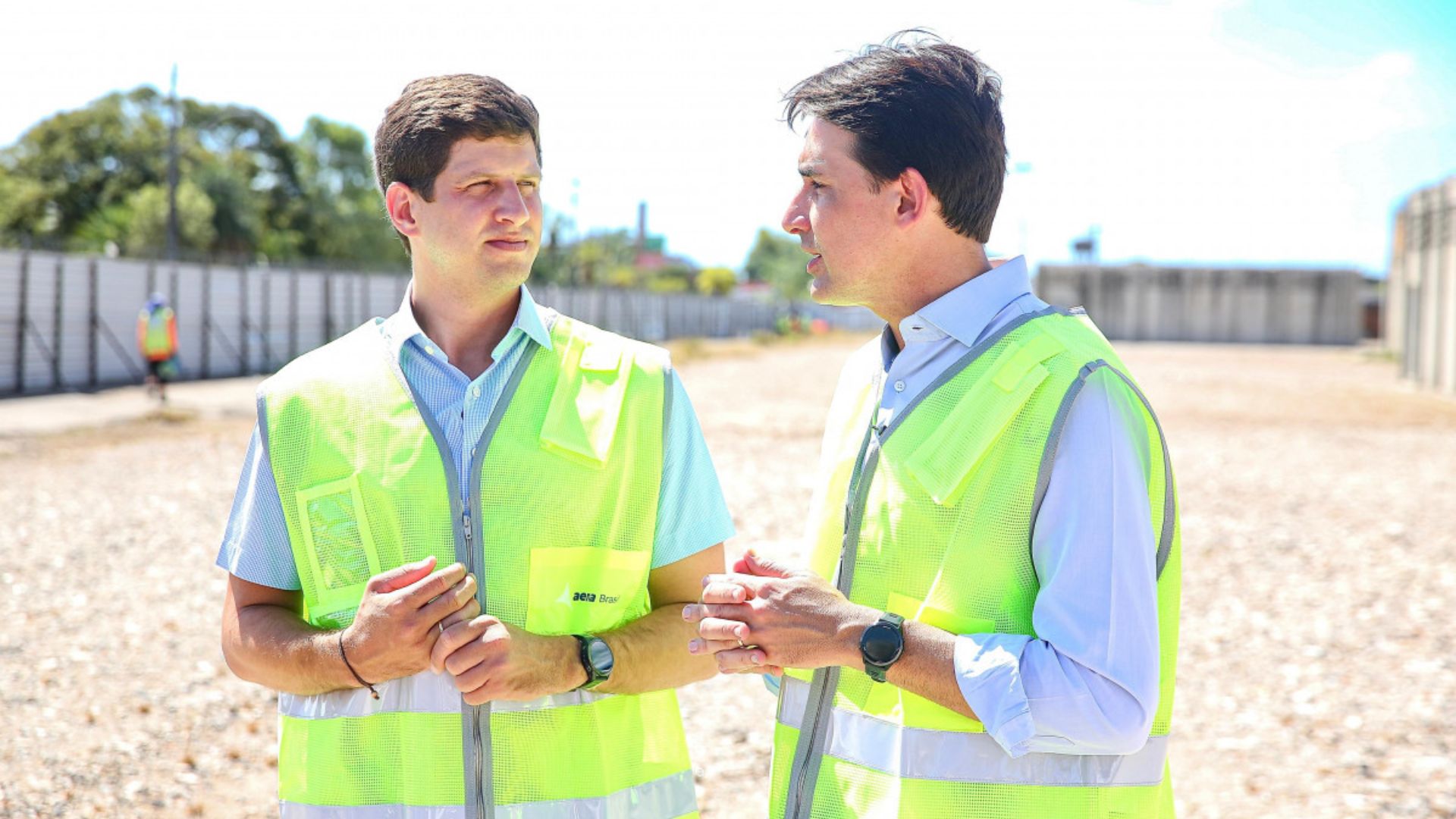 De coletes verde neon, João Campos e Silvio Costa Filho conversa. Ao fundo espaço vazio com areia