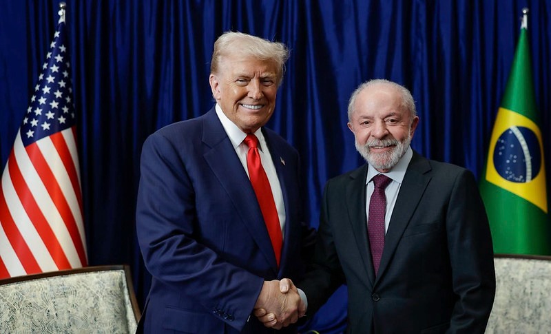 Donald Trump, presidente dos Estados Unidos e Lula, presidente do Brasil, apertando as mãos e sorrindo para a foto.