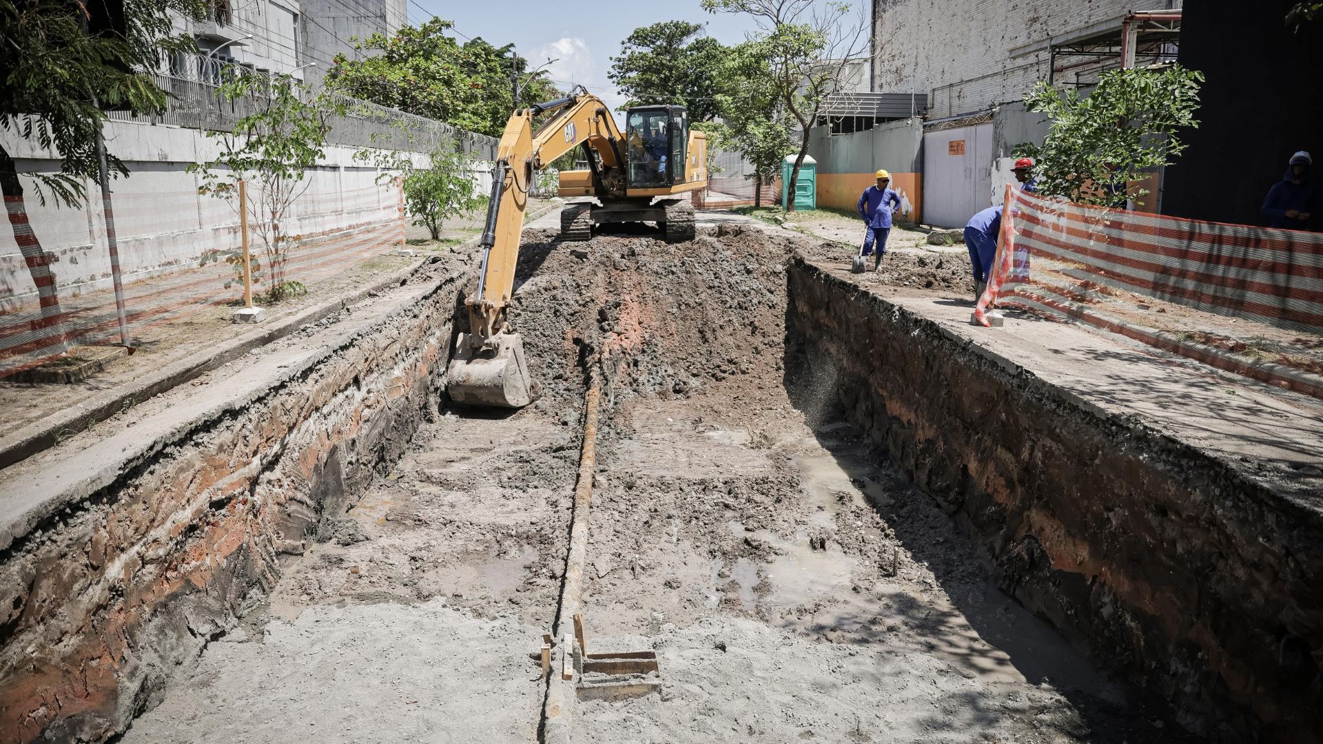 escavadeira retira terra de buraco fundo em formato quadrado