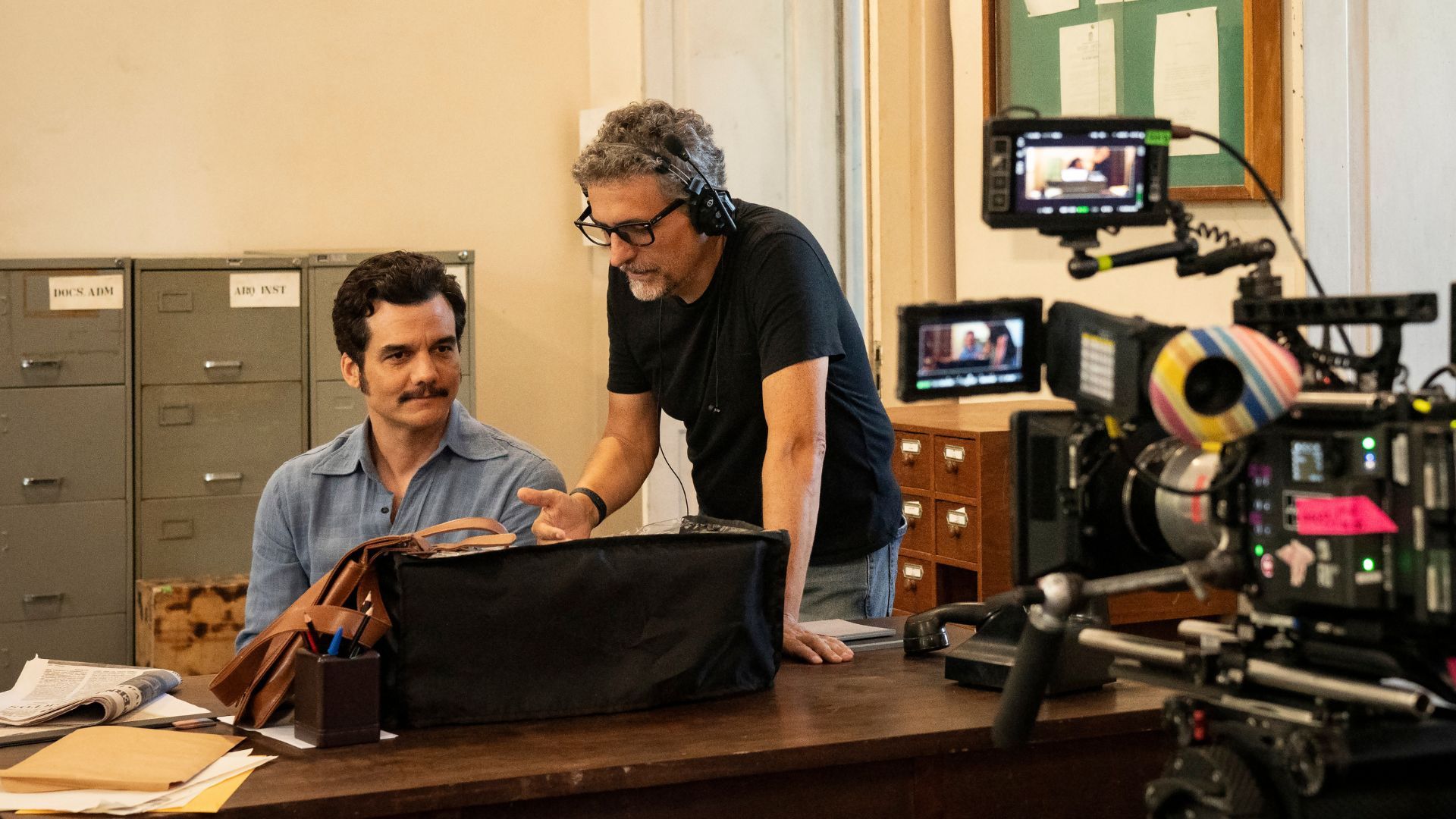 Câmera cinematográfica apontada para Kleber Mendonça Filho instruindo Wagner Moura.