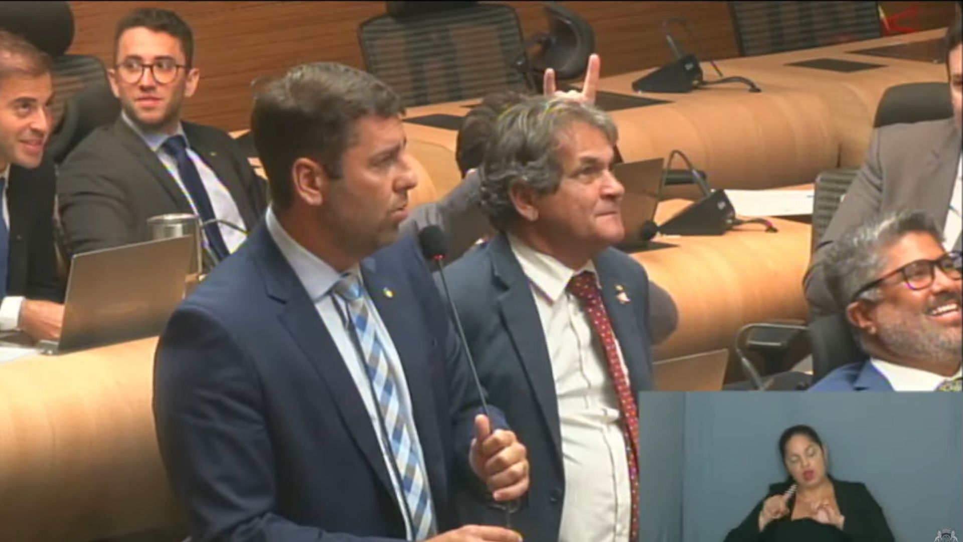 Eduardo Moura faz simbolo de chifre com a mão na cabeça de Chico Kiko enquanto Samuel Salazar fala e Rinaldo Júnior ri. Estão na plenária