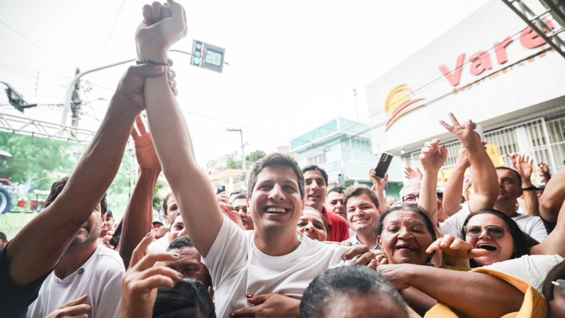 João Campos com o punho direito para cima, em meio à multidão